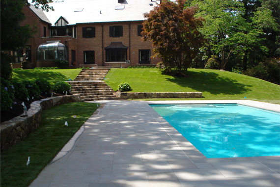 Pool deck with stairs leading up to house