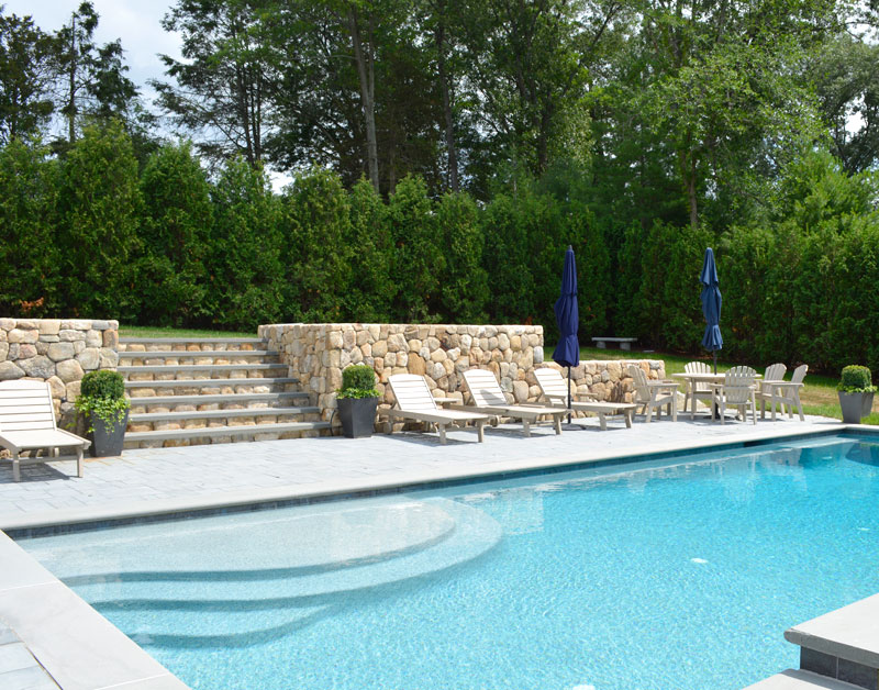 Pool deck with stone wall behind